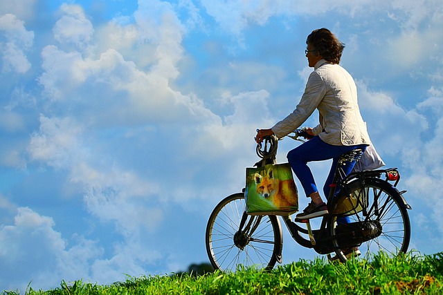 自転車で風を感じているイメージを青空の下で自転車に乗っている人の画像で表現