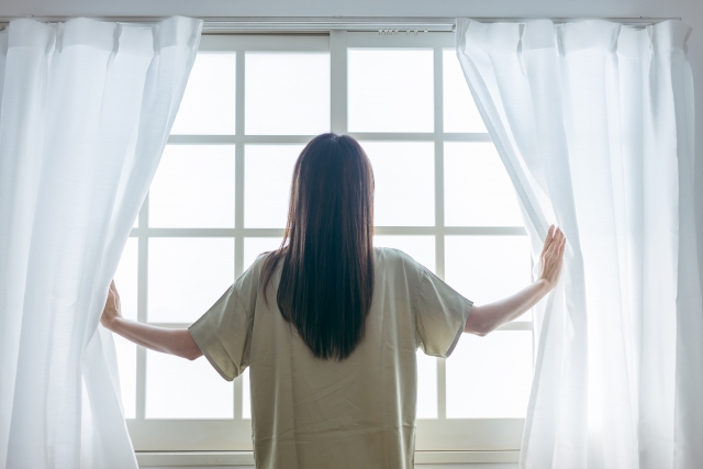 生き延びてきたイメージを、カーテンを開ける女性の画像で表現