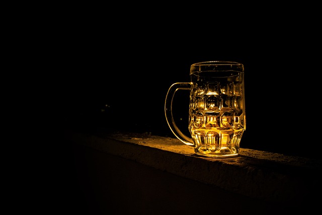 寝酒のイメージを、暗い部屋に置いたビールジョッキの画像で表現