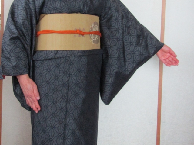 着付け講師に怒られるイメージを、着物を着て手を広げる女性の画像で表現
