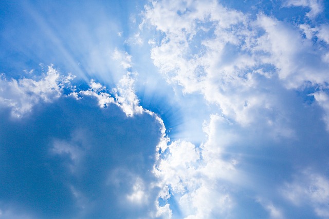 幸せな未来のイメージを雲の間から差す光の画像で表現