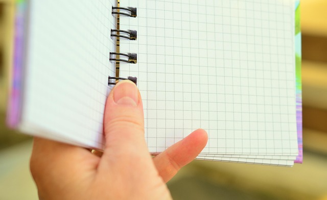 過去の絶望が書かれたメモ帳のイメージをメモ帳を持つ手の画像で表現