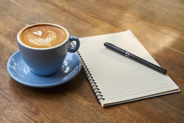 実験レポートのイメージを、コーヒーとノートとペンの画像で表現