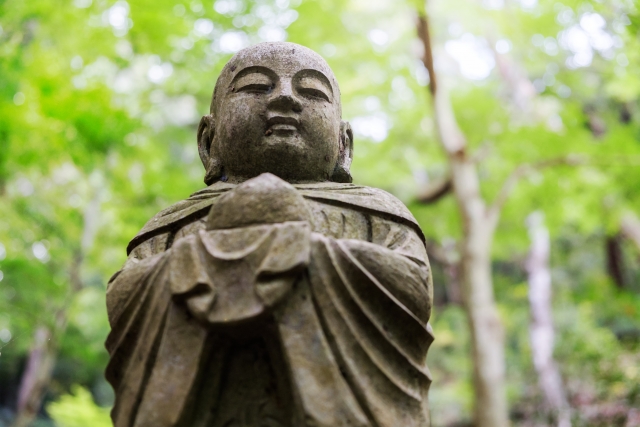 続けた人にしか見えない景色のイメージを、緑の中のお地蔵さんの画像で表現