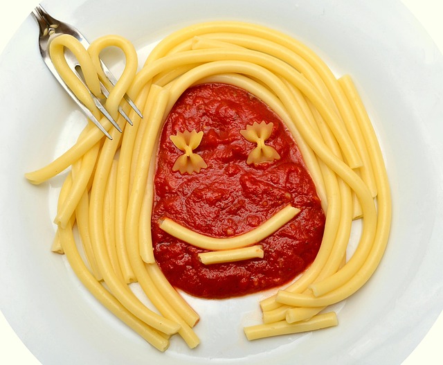 食事を楽しむイメージを、パスタで作った顔の画像で表現