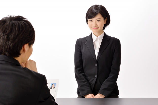面接のイメージを、スーツを着た女性と背中を向けた男性の画像で表現